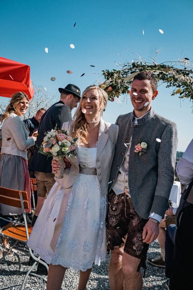 Brautpaar in Tracht im Konfettiregen