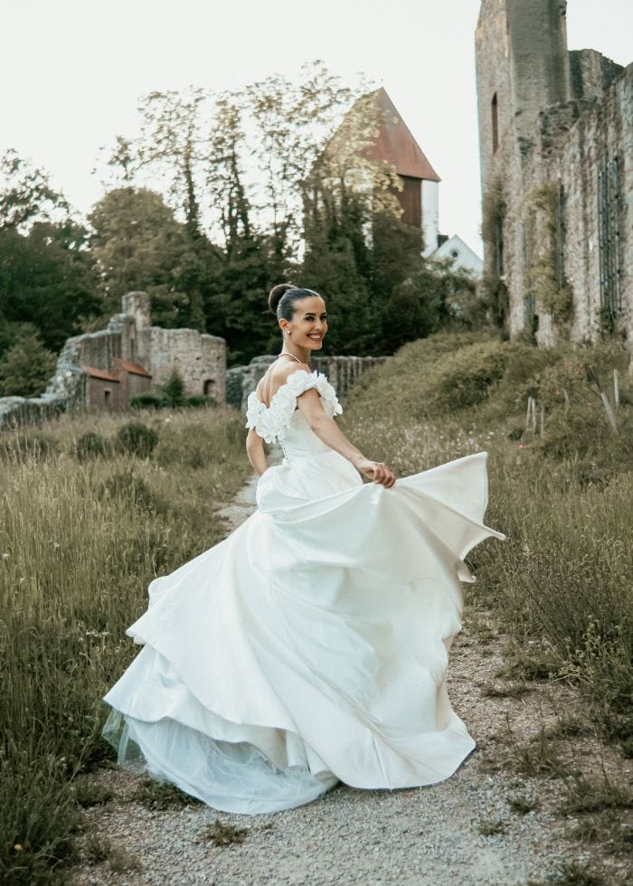 Braut vor Burgruine, Brautkleid im Wind